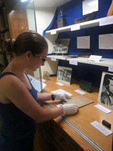 Rancho Los Cerritos' volunteer curatorial intern Nevada Evers installs the latest special exhibit in the library case in commemoration of the 175th anniversary of the adobe's construction (built in 1844) and specifically the sheep ranching years (1866-1929).
