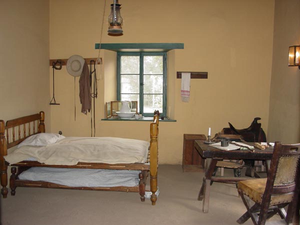Cozy rustic bedroom with bed and desk.
