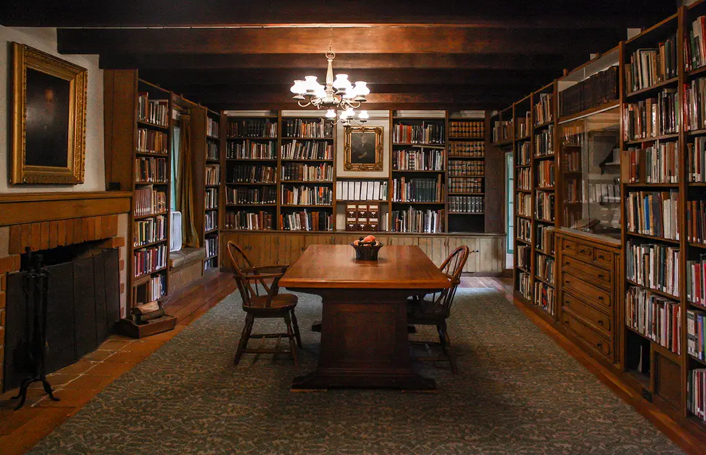 Cozy library room with wooden table and bookshelves