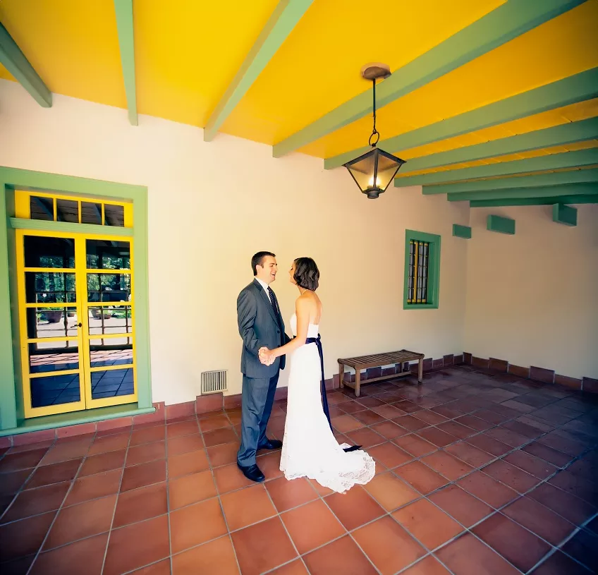 Couple holding hands in vibrant hallway.