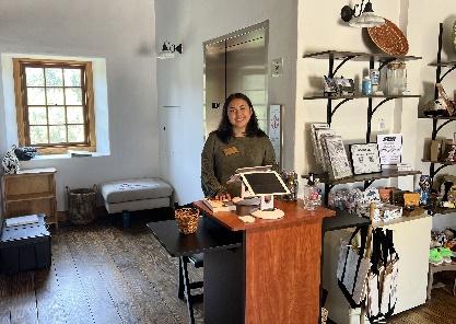 Woman standing at a shop counter.