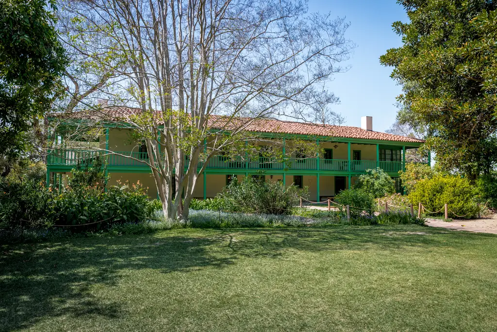 Historic two-story building with surrounding garden