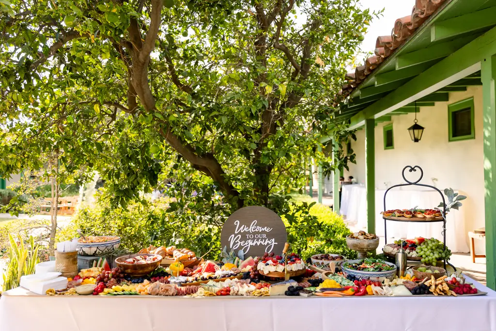 Outdoor buffet table with assorted appetizers and fruits.