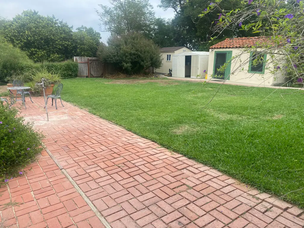 Backyard with patio and green grass lawn.