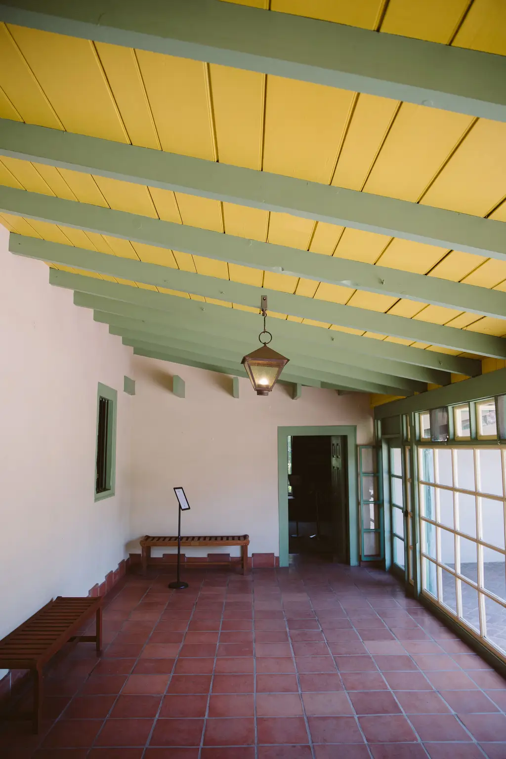Sunny veranda with colorful ceiling and tile floor.