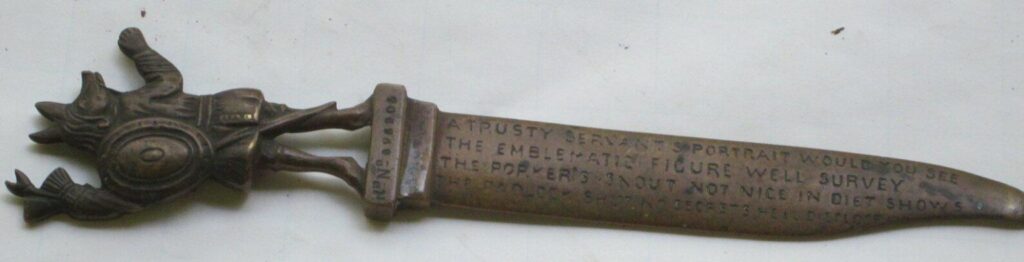 Ornate dagger with inscribed text and animal figure.