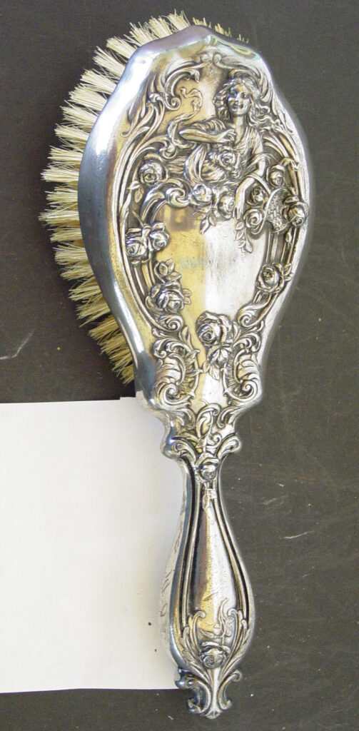 Ornate silver hairbrush with intricate floral design