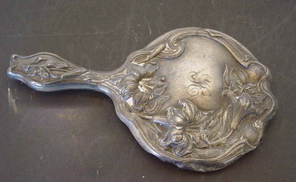 Ornate antique hand mirror with floral design