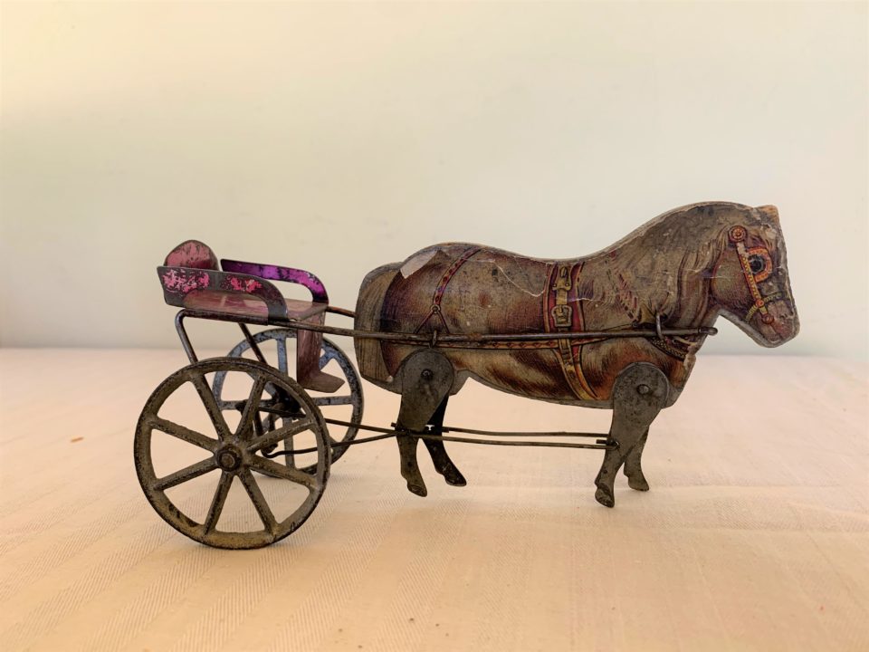 Vintage toy horse with metal wheels.