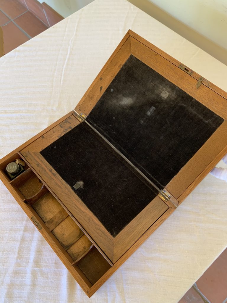 Open wooden box with compartments and black interior