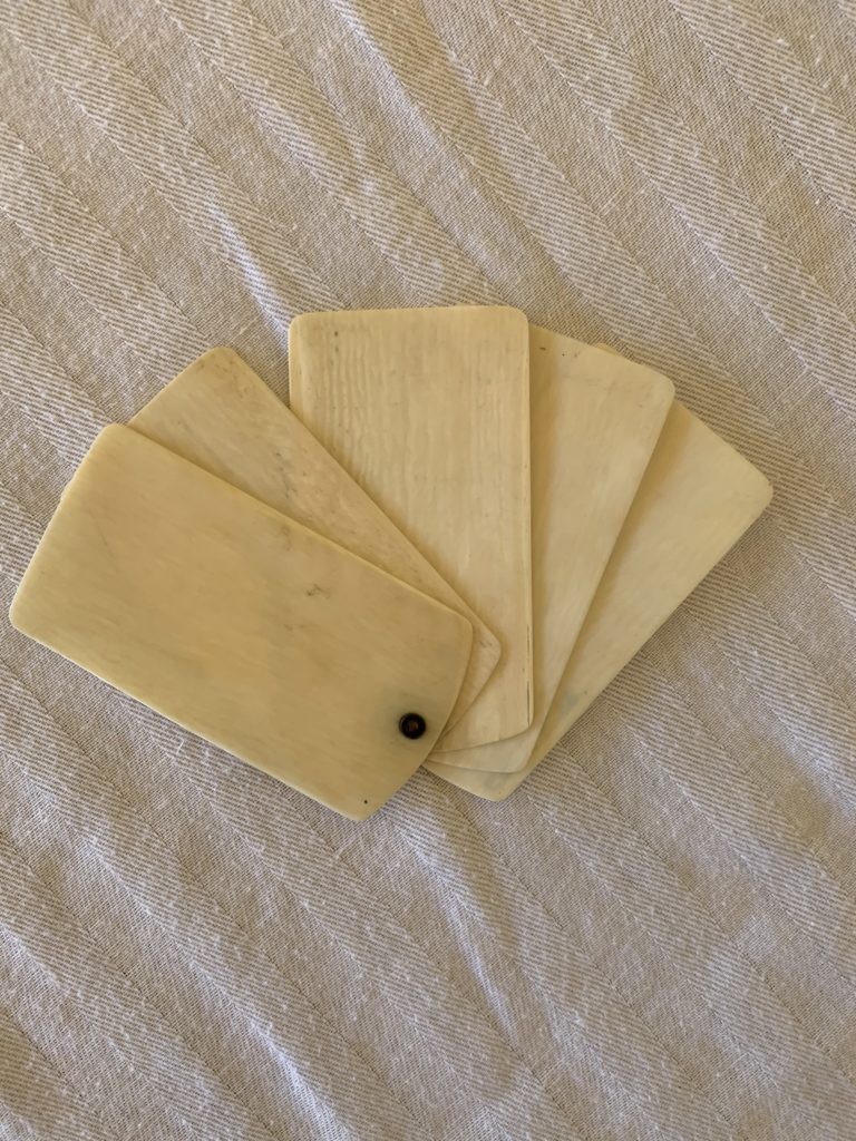 Five ivory chips on textured fabric surface