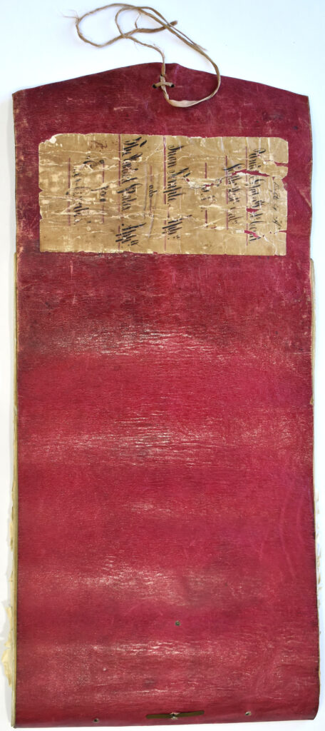 Vintage red writing tablet with inscriptions, hanging loop