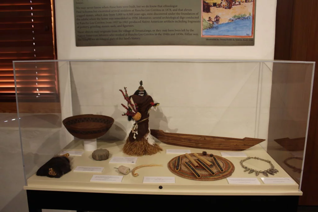 Exhibit of native artifacts in a glass display case.