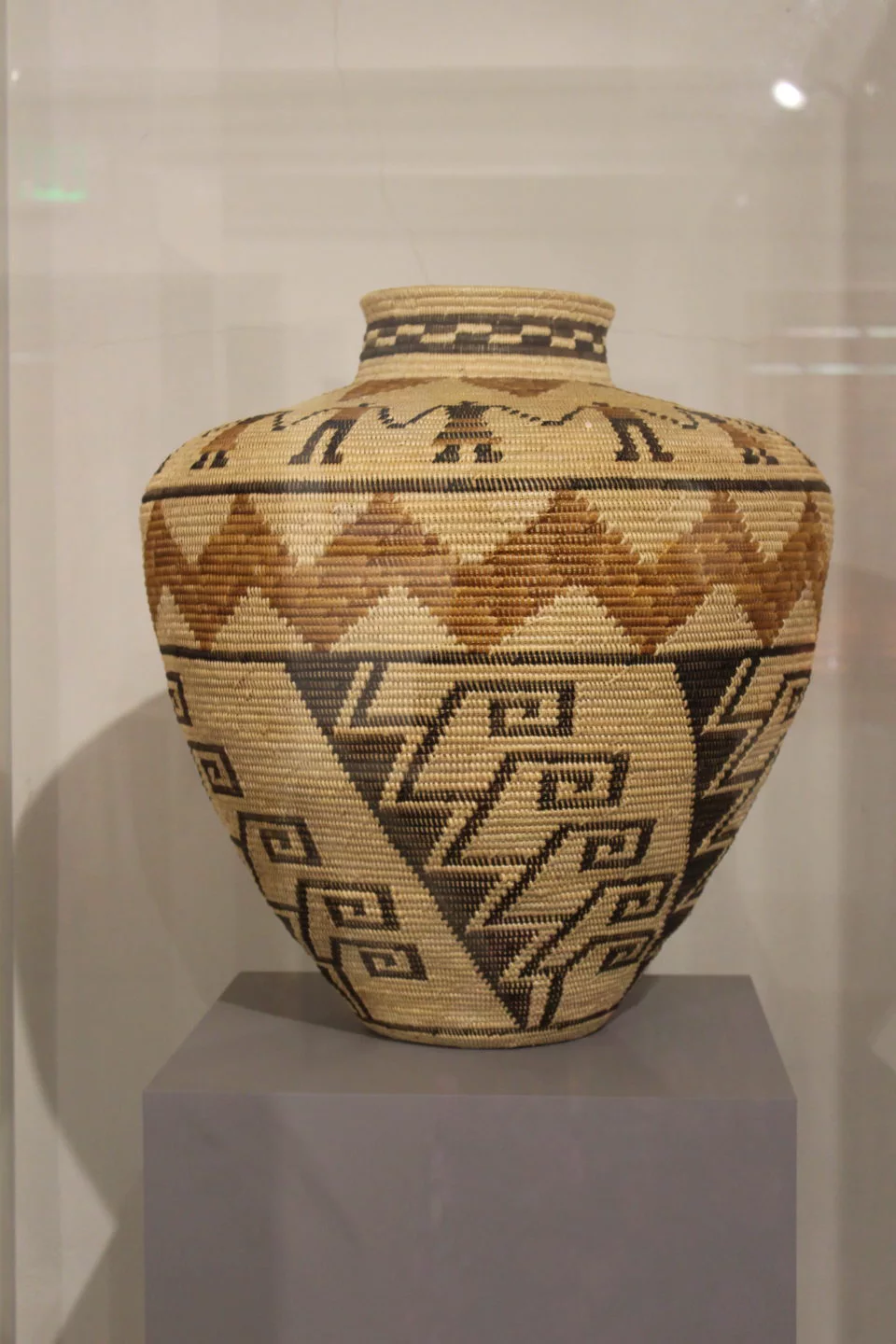 Intricately patterned woven basket on display.