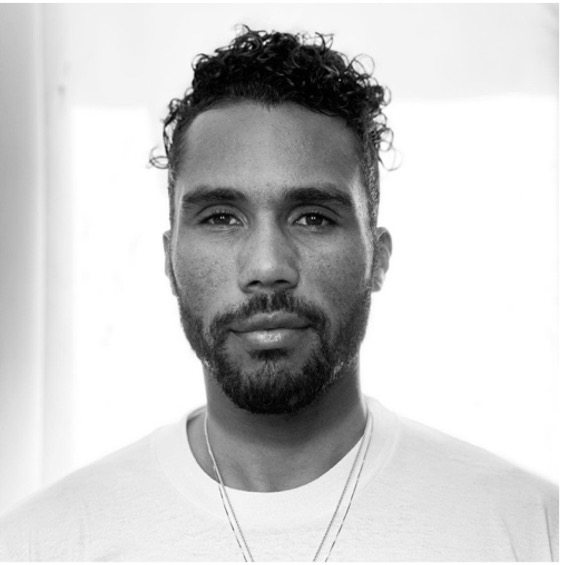 Portrait of a person with curly hair and beard.