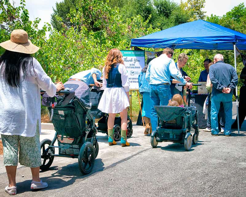 People gathered under a canopy at an outdoor event.